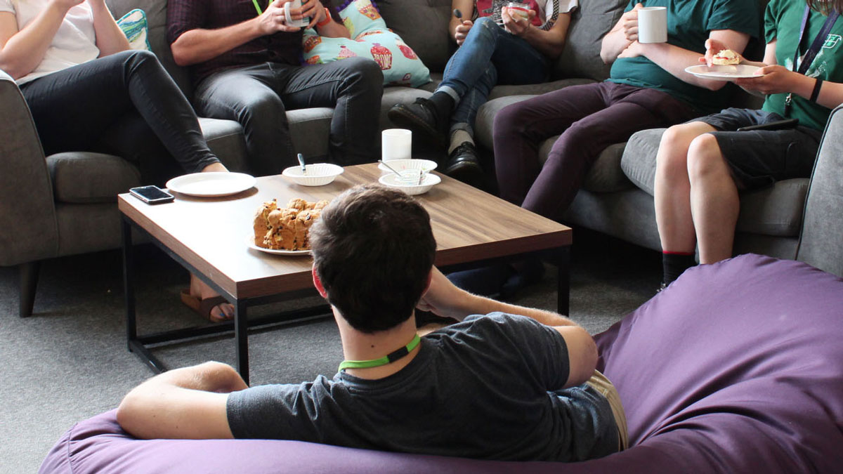 A group of Bluefruit colleagues sit in our Chill Out Room having cream teas and saffron cake.