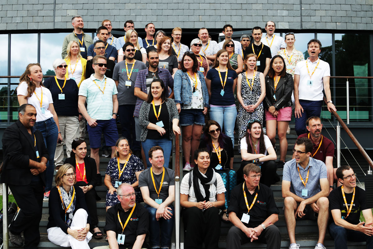 Agile on the BEach speakers and organisers stand on the steps of the AMATA centre at Univeristy Falmouth.